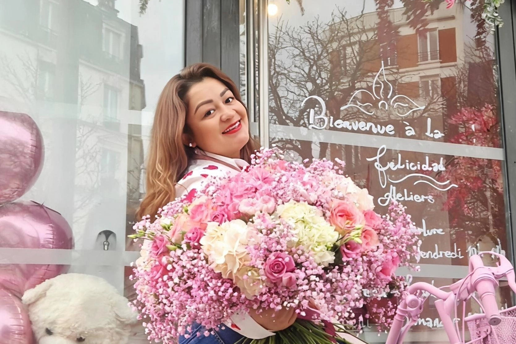 Photo de la commerçante tenant un bouquet devant la devanture de la boutique de La Felicidad