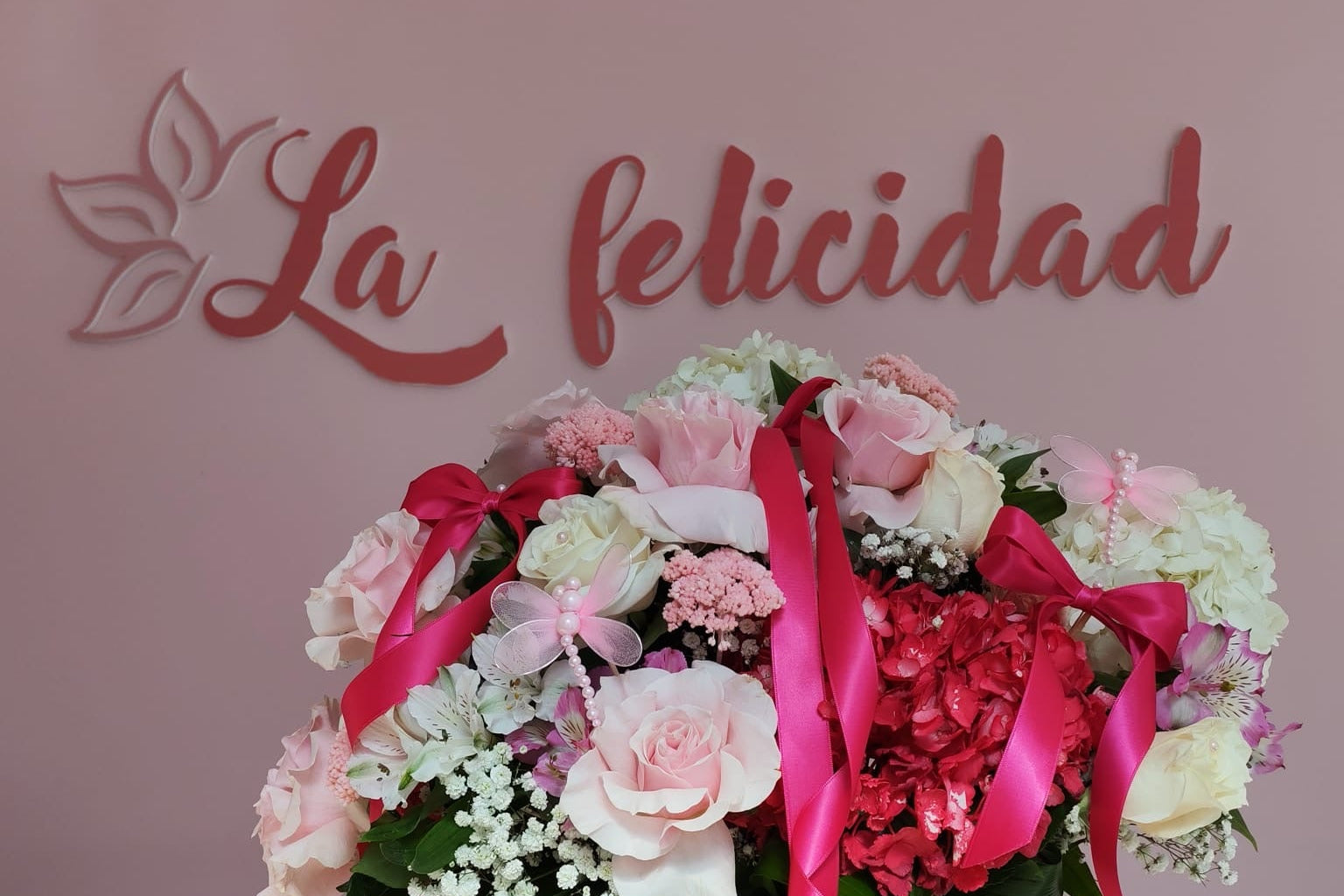 Photo d'un bouquet derrière le logo de La felicidad en boutique 